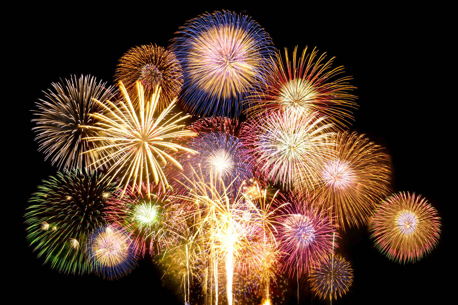 Colorful fireworks explode in the night sky, with gold, blue, red, and pink bursts filling the frame.